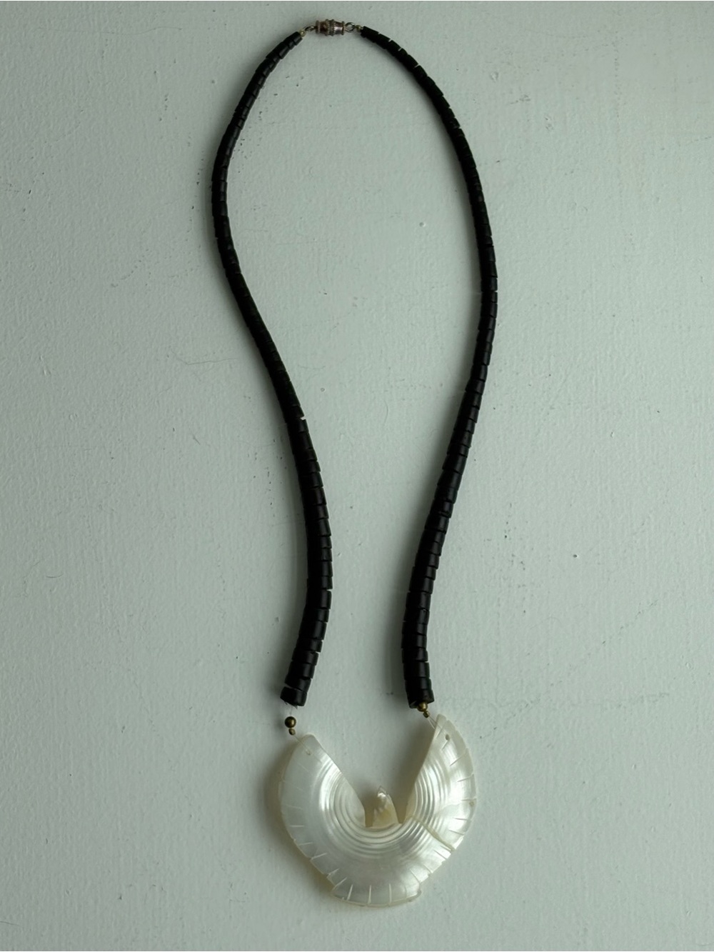 Vintage hand-carved mother of pearl bird pendant on black wood bead necklace